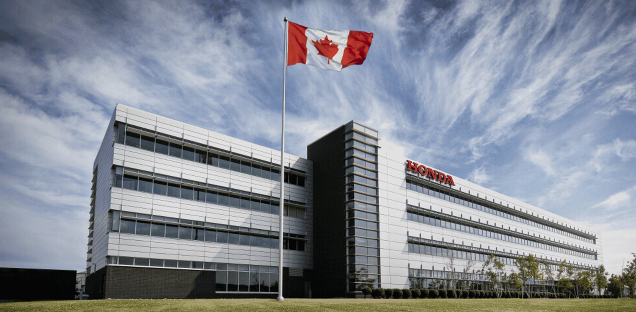 Honda Canada’s headquarters with a Canadian flag waving on a flagpole.