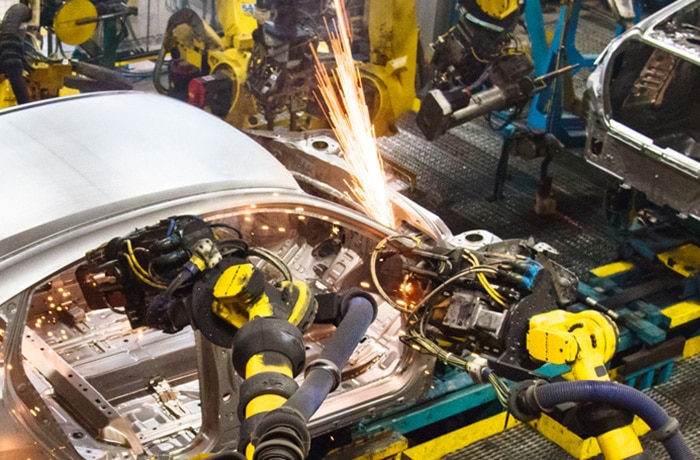 A robot welds a Honda vehicle's frame.