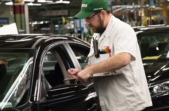 A Honda associate inspects a new vehicle.